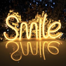 SMILE - neon LED illuminated light sign hanging on the wall