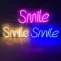 SMILE - neon LED opplyst lysskilt hengende på veggen